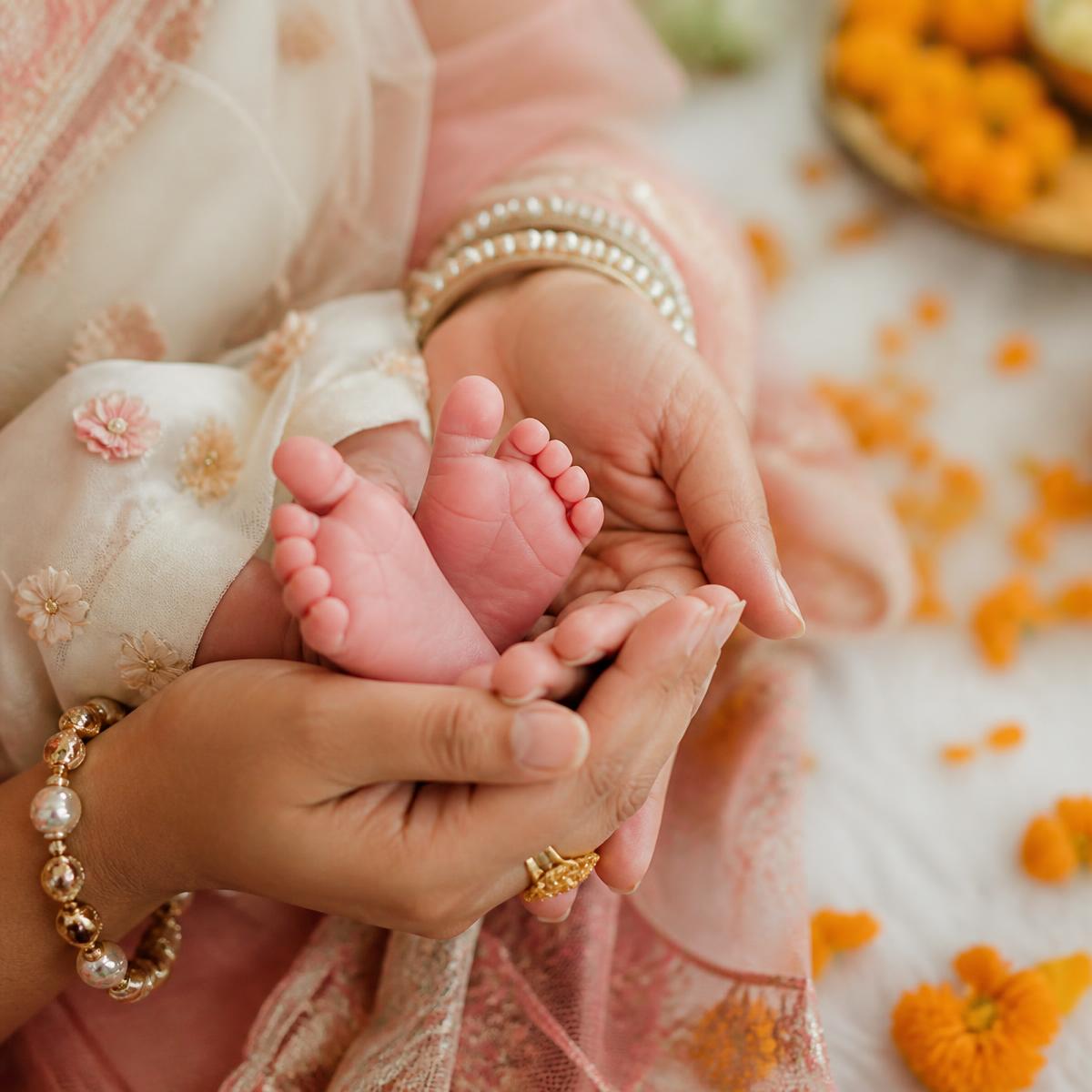 A mother holding her newborn baby's tiny feet